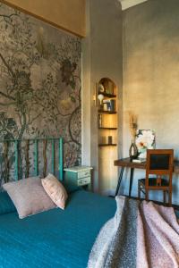 1 dormitorio con cama azul, escritorio y pared en Como Bellevue Rosselli, en Como