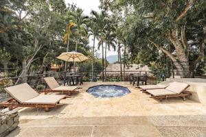 a patio with chairs and an umbrella and a pool at Hotel Quimbaya in San Jerónimo