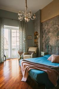 Un dormitorio con una cama azul y una lámpara de araña. en Como Bellevue Rosselli, en Como