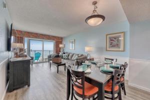 a dining room and living room with a table and chairs at 2007 S Ocean Blvd, 0406 - Ocean Front Sleeps 10 in Myrtle Beach