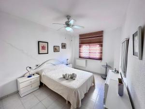 1 dormitorio blanco con 1 cama y ventilador de techo en Apartamento Centrico en Torremolinos, en Torremolinos