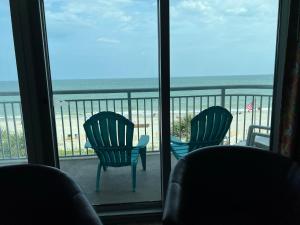 three chairs sitting on a balcony looking out at the beach at 2007 S Ocean Blvd, 0406 - Ocean Front Sleeps 10 in Myrtle Beach