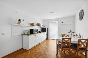 a kitchen with white cabinets and a table and chairs at Apartment Oase for Four in Merseburg