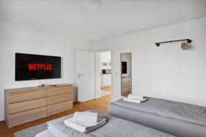 a bedroom with two beds and a tv on the wall at Apartment Oase for Four in Merseburg