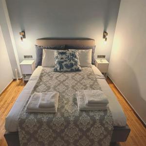um quarto com uma cama grande com duas toalhas em Osiris Hideaway Inn, Kerameikos, Athens, Industrial 2-br apt, balconies & Netflix em Atenas