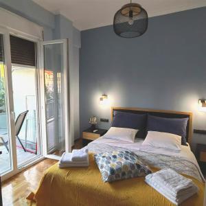 um quarto com uma cama grande e uma parede azul em Osiris Hideaway Inn, Kerameikos, Athens, Industrial 2-br apt, balconies & Netflix em Atenas