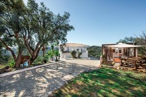 a driveway leading to a house with a table and a bench at Casa Nostra in Tavira