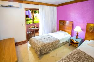 una camera d'albergo con due letti e una finestra di Resort Arcobaleno All Inclusive a Porto Seguro