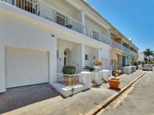 a white apartment building with a white garage at Tranquil Family Home in Green Point in Cape Town