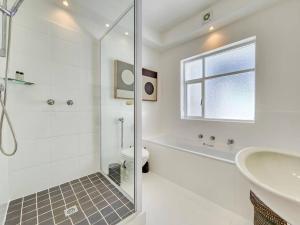 a bathroom with a tub and a toilet and a sink at Tranquil Family Home in Green Point in Cape Town