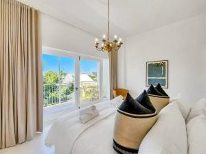 uma sala de estar com um sofá branco e uma janela em Tranquil Family Home in Green Point em Cidade do Cabo