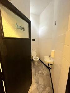 a bathroom with a toilet and a black door at Don Enrique Bar&Hostel in San Gregorio