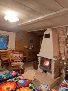 a living room with a fireplace and a table and chairs at Agroturystyka LipoweWzgórze domek Antek in Tereszpol