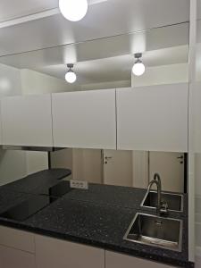 a kitchen with a black counter top and a sink at BG Exclusive Apartment in Belgrade