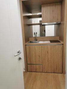 uma pequena cozinha com um lavatório e um espelho em BG Exclusive Apartment em Belgrado