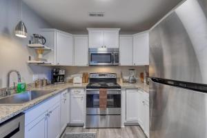 a kitchen with white cabinets and stainless steel appliances at 1408 Perrin Dr, Unit D - Ocean Walk Sleeps 8 in Myrtle Beach