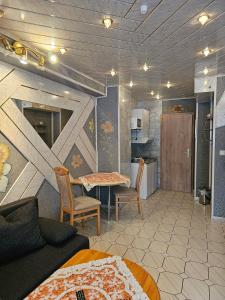 a bedroom with a table and chairs and a kitchen at Hotel Tenne in Viernheim