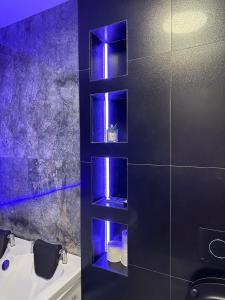 a bathroom with blue lights on the wall at Apartament de Lux André in Sibiu +6 photos