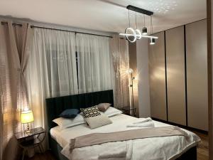 a bedroom with a large bed and a chandelier at Apartament de Lux André in Sibiu