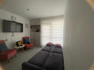 a living room with a couch and two chairs at Apartamento ideal para tus vacaciones in Girardot