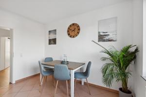 a dining room with a table and chairs and a clock at *NulandtApartment* in Merseburg