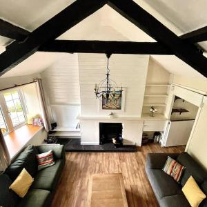 Country Cottage with Hot-Tub and Cosy Log Burner في Tregarth: غرفة معيشة مع أريكة ومدفأة