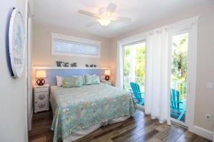 Schlafzimmer mit einem Bett und einem Deckenventilator in der Unterkunft Ocean Breeze (AMIL) in Bradenton Beach