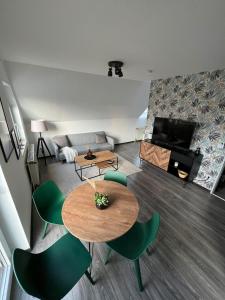 sala de estar con mesa y sillas verdes en No2 by 21 Apartments, en Kaarst
