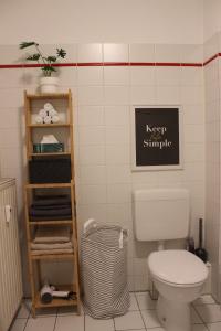 a bathroom with a toilet and a sign on the wall at No2 by 21 Apartments in Kaarst