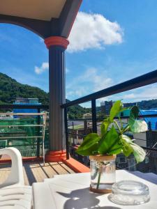 a balcony with a table with a plant on it at Kata Lina guesthouse in Kata Beach