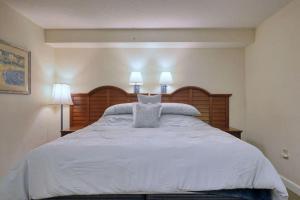 a bedroom with a large white bed with two lamps at 2501 S Ocean Blvd, 1115 - Ocean View Sleeps 8 in Myrtle Beach