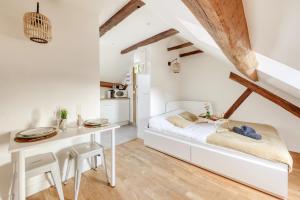 ein Schlafzimmer mit einem weißen Bett und einem Tisch in der Unterkunft Élégance à la Versailles in Versailles