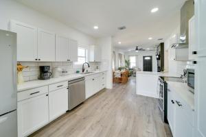a white kitchen with white cabinets and wooden floors at Charming San Antonio Home about 2 Mi to The Alamo! in San Antonio