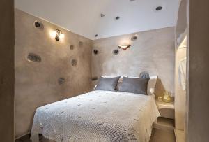 una camera da letto con un letto con copriletto bianco di Luxury Villas Hariton a Emporio