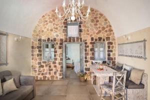 sala de estar con mesa y pared de piedra en Luxury Villas Hariton, en Emporio