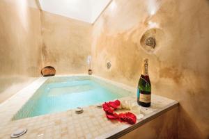 a bottle of champagne sitting next to a swimming pool at Luxury Villas Hariton in Emporio Santorini