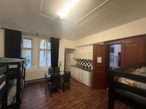 a room with a table and chairs and a kitchen at Hostel Moon in Prague