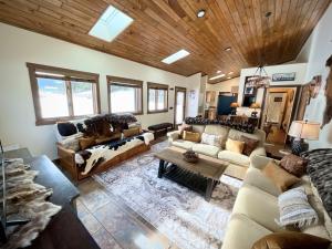 una sala de estar con sofás y techo de madera. en Ski Chalet, en Gallatin Gateway