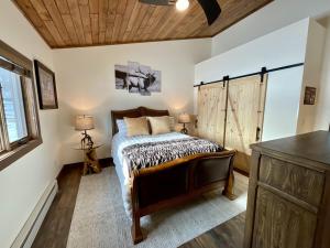 1 dormitorio con cama y techo de madera en Ski Chalet, en Gallatin Gateway