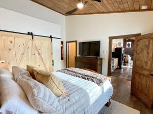 1 dormitorio con 1 cama con TV y puerta corredera de granero en Ski Chalet, en Gallatin Gateway