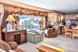 a living room with furniture and a kitchen with a large window at Spectacular Views, Pool, Hot Tub, Mountain Village in Big Sky