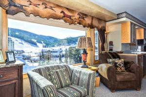 a living room with two chairs and a large window at Spectacular Views, Pool, Hot Tub, Mountain Village in Big Sky