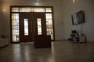 Sala de estar con puerta y TV en Havana Comfort en Dar es Salaam