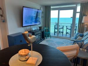 a living room with a table and a view of the ocean at 2501 S Ocean Blvd, 1101 - Ocean Front Sleeps 8 in Myrtle Beach