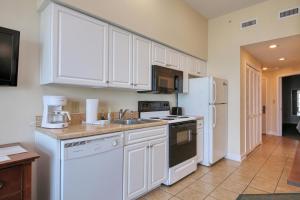 uma cozinha com electrodomésticos brancos e armários brancos em 2501 S Ocean Blvd, 1205 - Ocean Front Sleeps 6 em Myrtle Beach