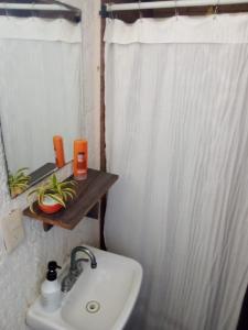 a bathroom with a sink and a white shower curtain at Naranjo Hostel in Cancún