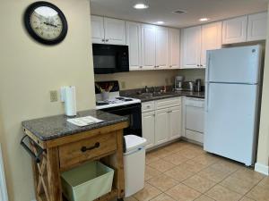 a kitchen with white cabinets and a white refrigerator at 2501 S Ocean Blvd, 0811 - Ocean Front Sleeps 8 in Myrtle Beach