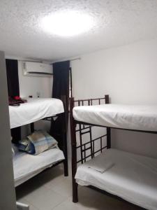 Zimmer mit 3 Etagenbetten und einer Lampe in der Unterkunft Naranjo Hostel in Cancún