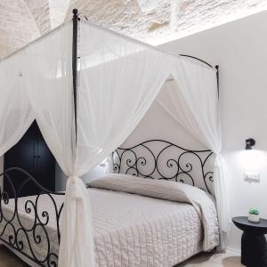 una camera con un letto bianco a baldacchino di B&B Rhea Luxury a Terlizzi