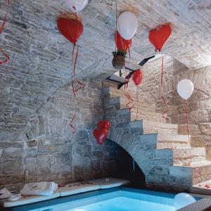 una stanza con palloncini rossi e bianchi e un muro di mattoni di B&B Rhea Luxury a Terlizzi